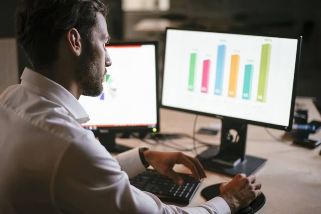 man looking into computer with chart